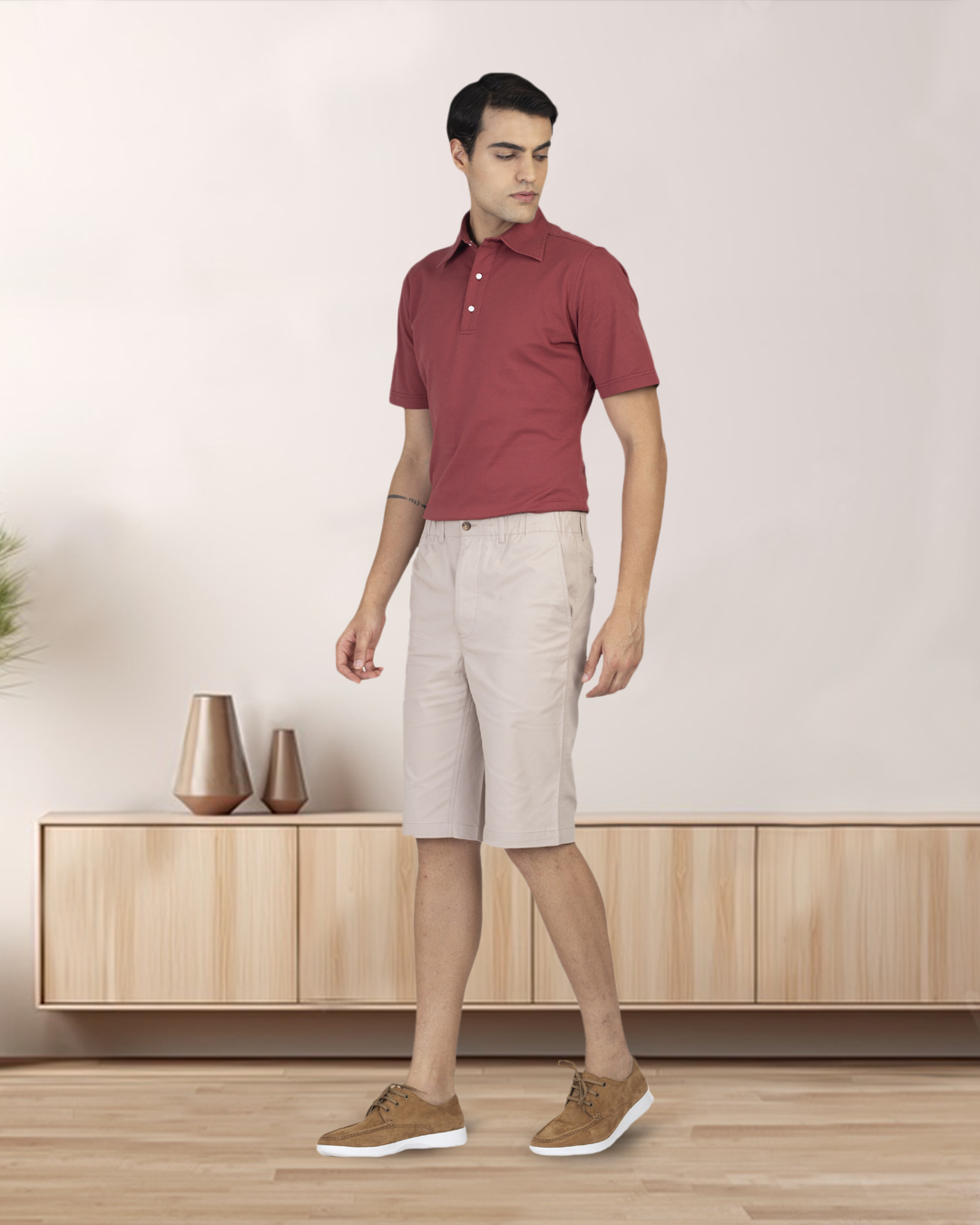 Model wearing custom Genoa shorts for men by Luxire in pale green wearing tan shoes and red top