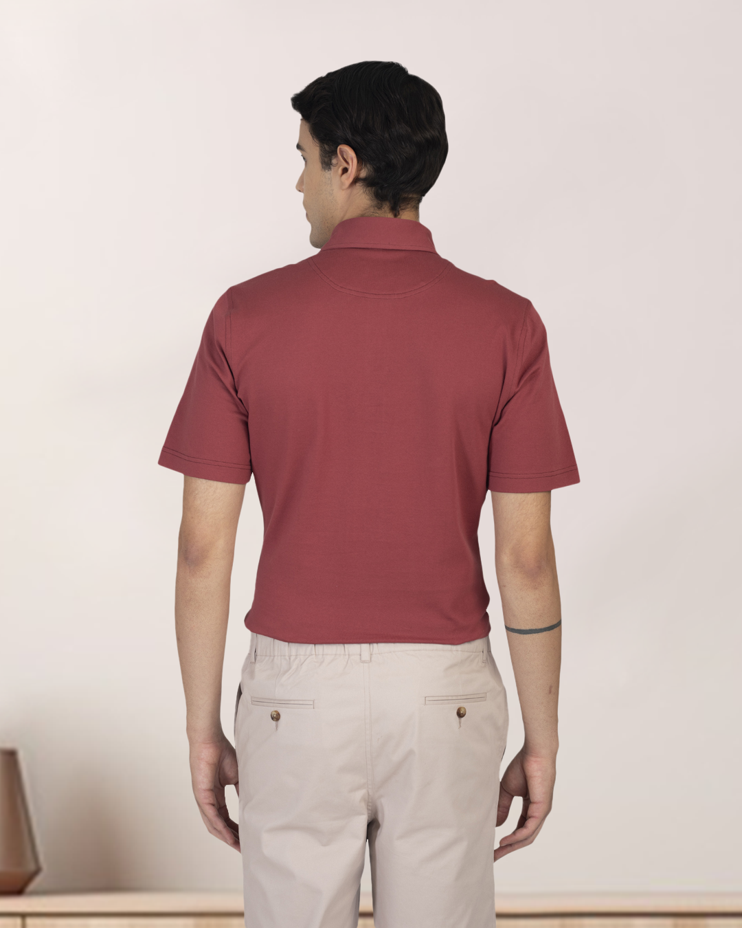 Back view of model wearing custom Genoa shorts for men by Luxire in pale green wearing red top