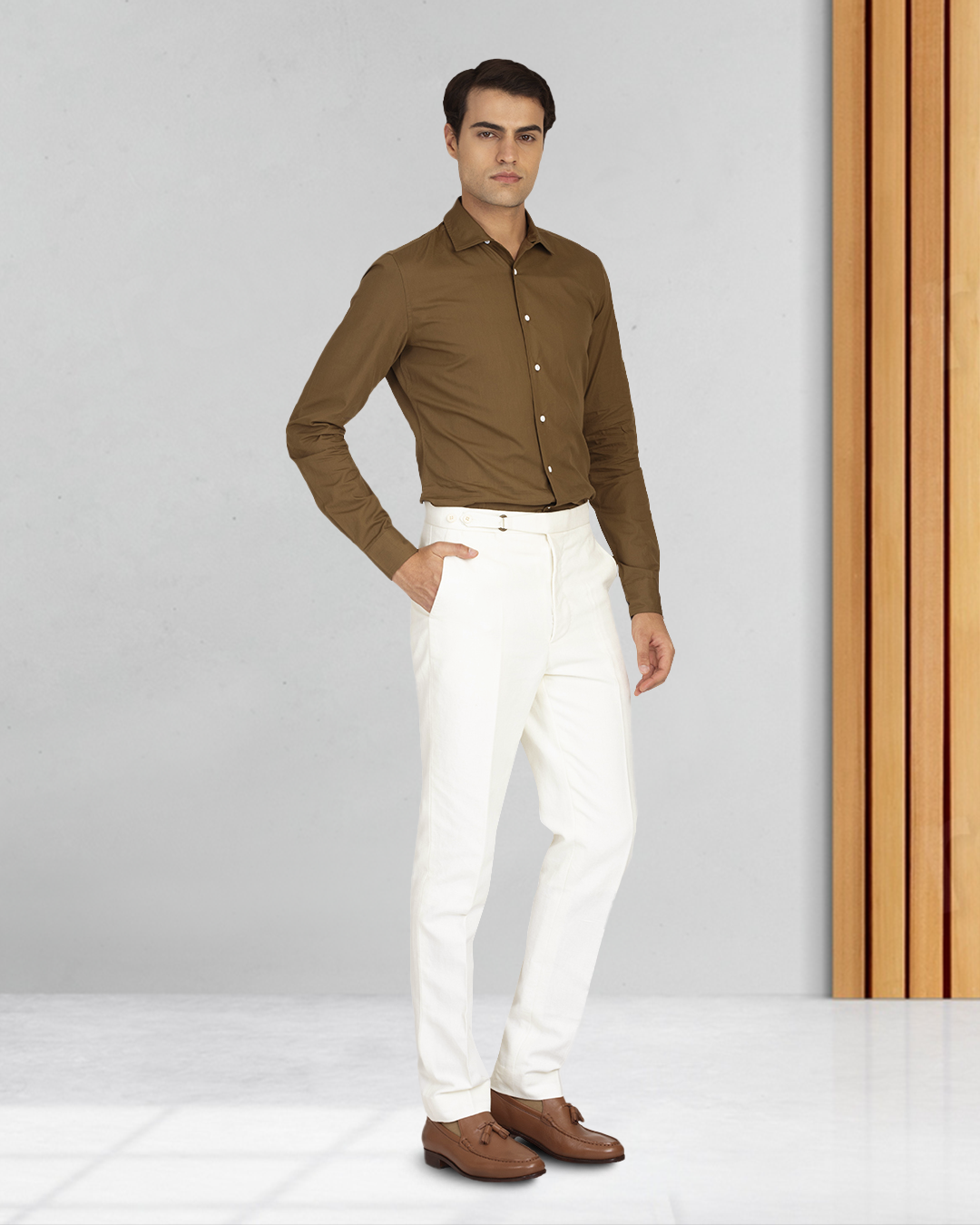Male model wearing custom linen canvas pants for men by Luxire in white with hand at side