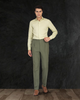 Male model wearing custom linen canvas pants for men by Luxire in olive green with hand at his side