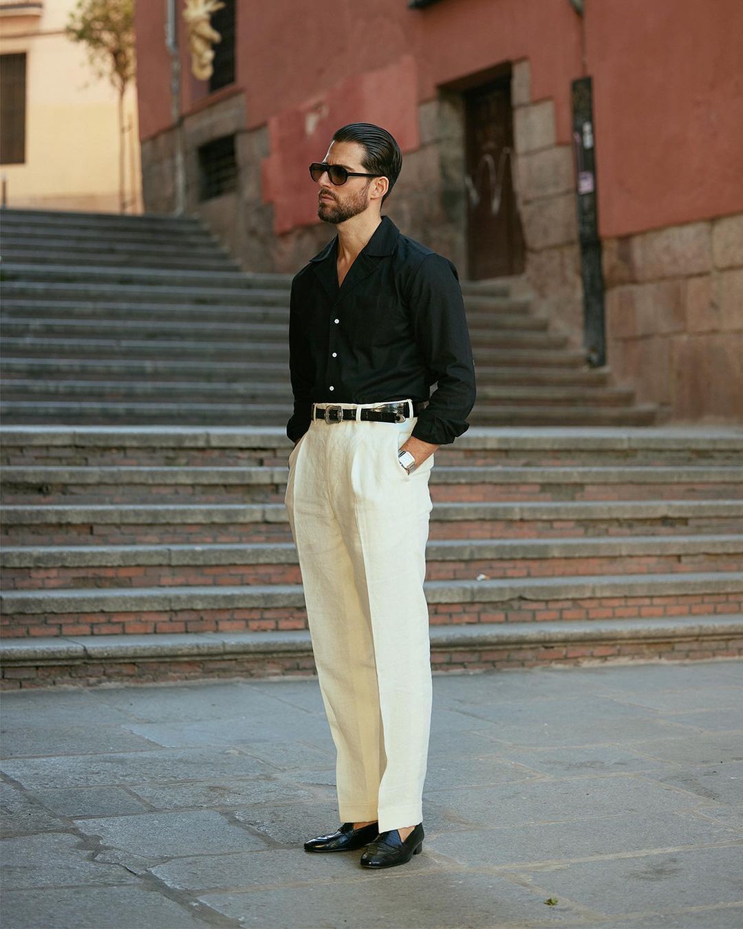 Model in front of stairs wearing custom linen Gurkha pants for men by Luxire in cream