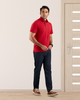 Model wearing the custom oxford polo shirt for men by Luxire in red hands together 2